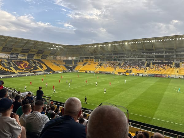 Football match underway in Plovdiv stadium under overcast skies