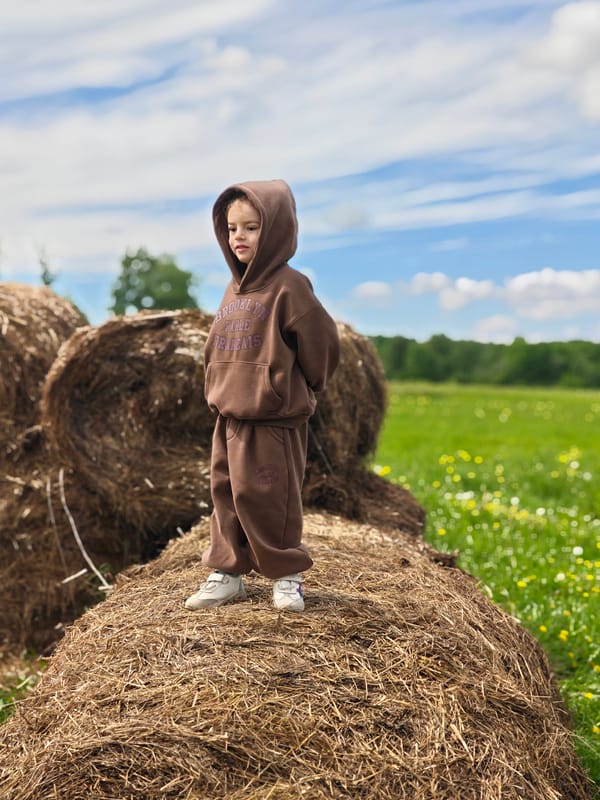 Child plays on hay bales in Russian countryside
