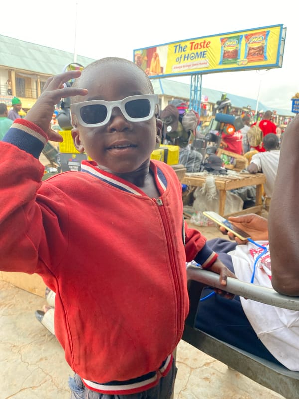 Child in sunglasses photographed at Bukuru street market