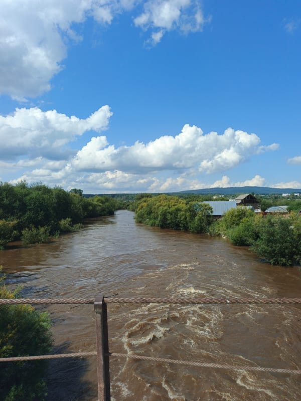 Muddy river and log construction in rural Medvedyovka, Russia