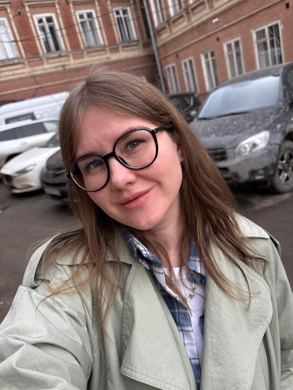 Woman takes selfies on Perm street under overcast sky