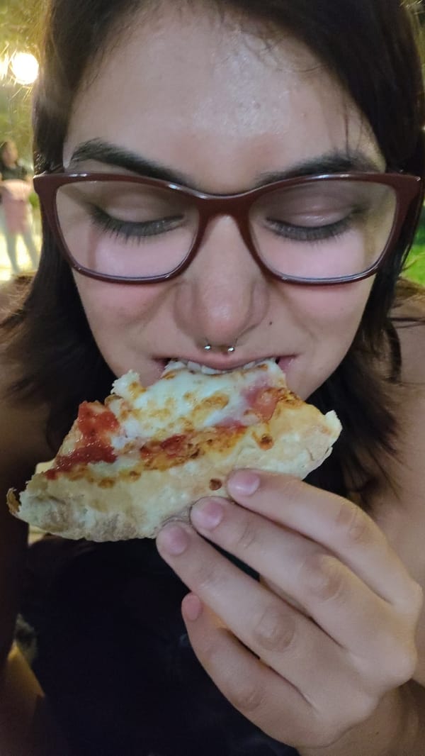 Woman eats pizza late night in Barranco, Peru