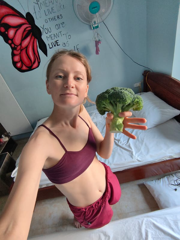 Woman holds broccoli in bedroom, Bai Chay Ward