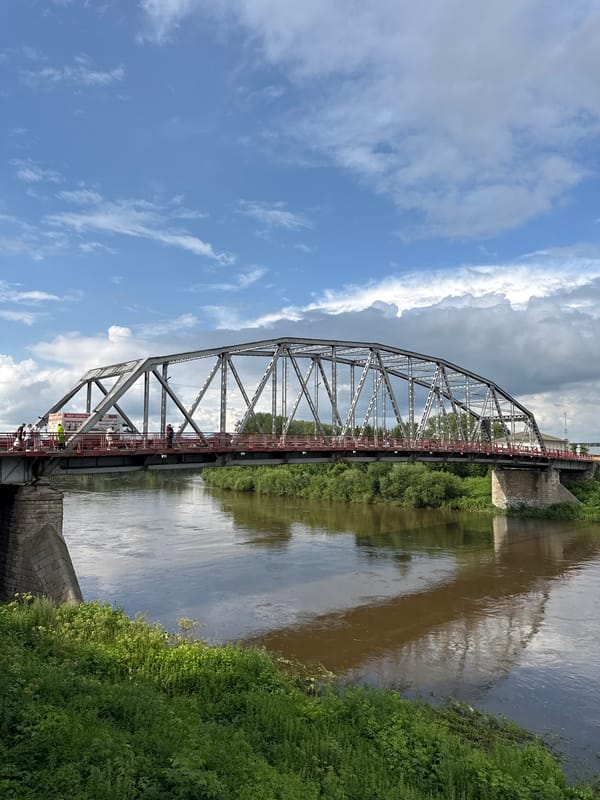 Steel truss bridge and muddy riverbank in Kungur, Russia