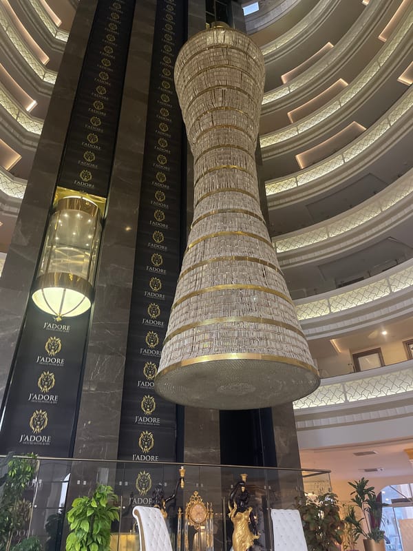 Hotel atrium's grand chandelier captured in upward architectural view