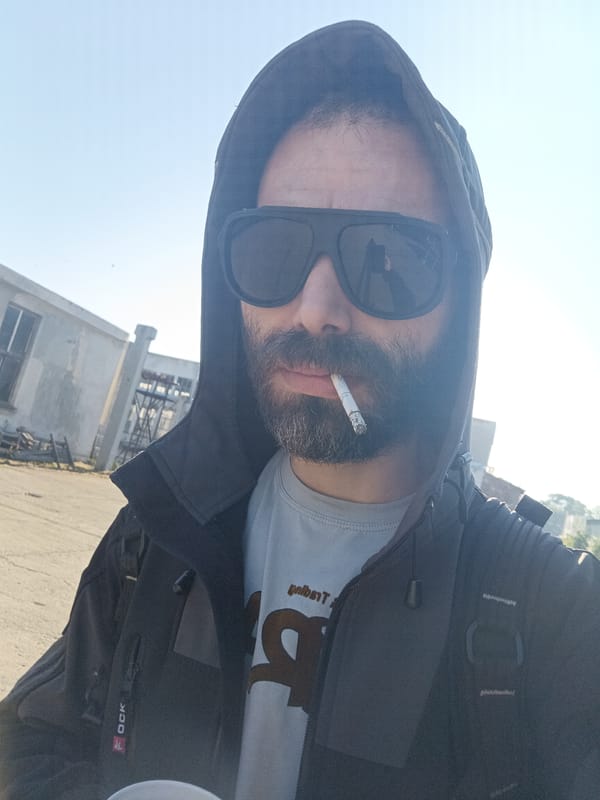 Man smoking cigarette outdoors near building early morning