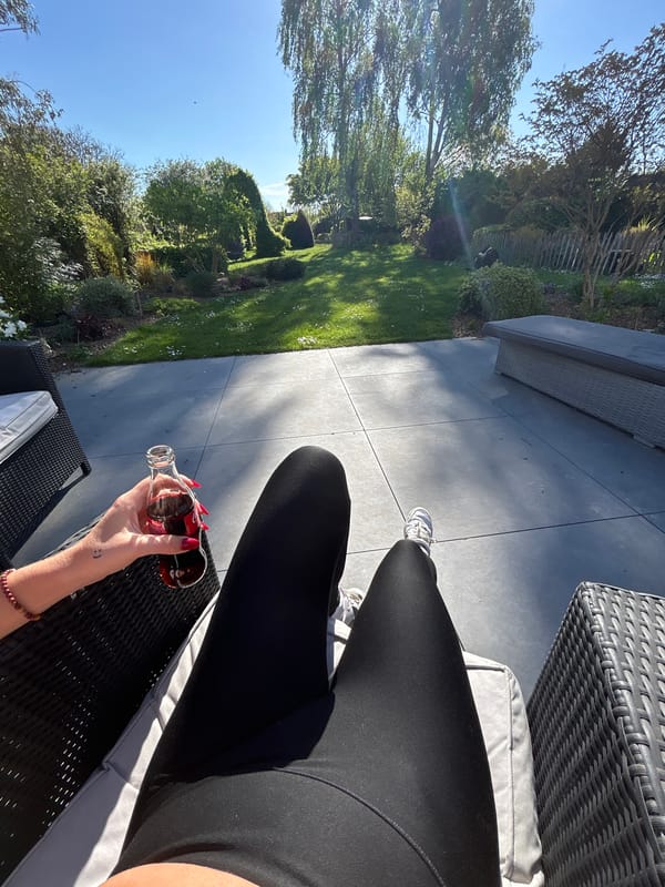 Woman relaxes with phone, dog in French garden