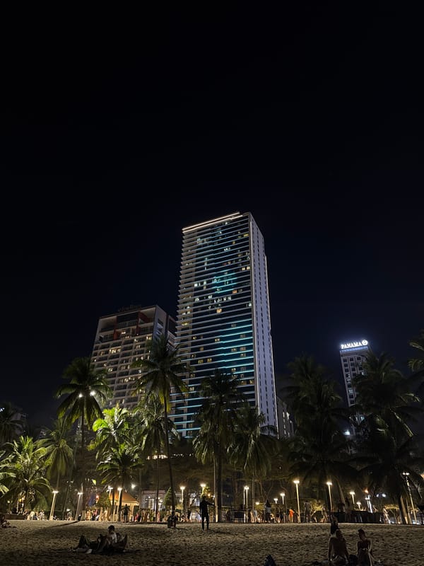 Street musician performs near Nha Trang skyscrapers under full moon