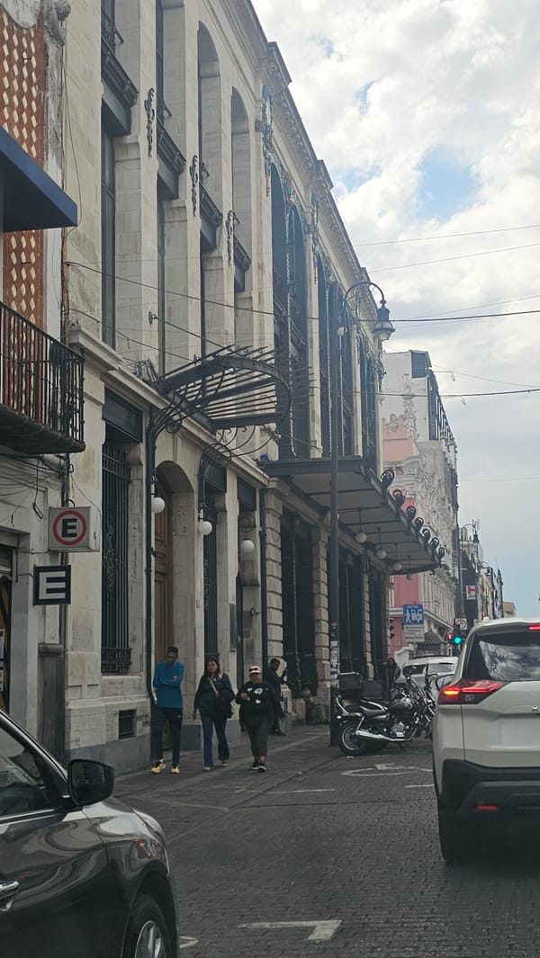 Street scene captured in Puebla showing white architectural building