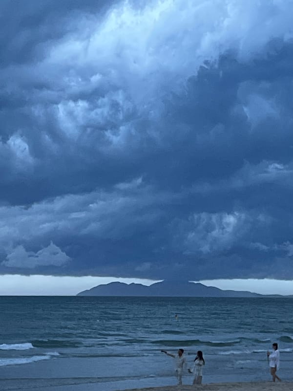 Storm clouds gather over Đà Nẵng beach evening scene