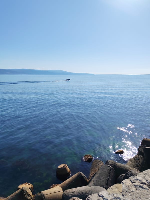 Nesebar's coastal walkway and breakwaters on a sunny morning