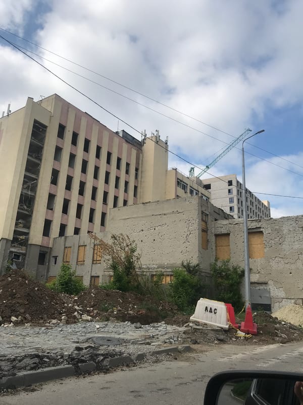 War-damaged building in Kharkiv with boarded windows and bullet holes