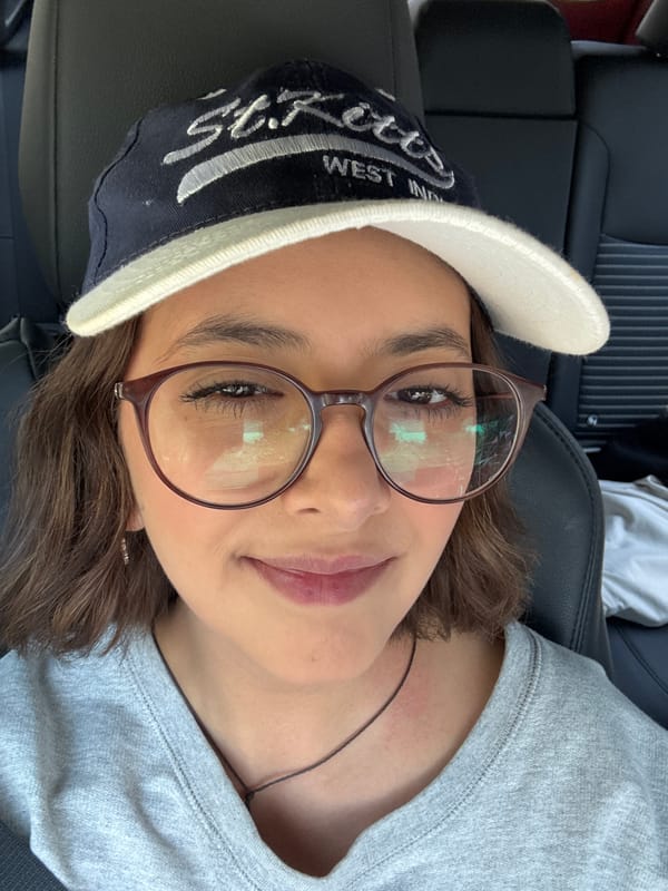 Person rests in vehicle wearing St. Kitts cap in Puebla