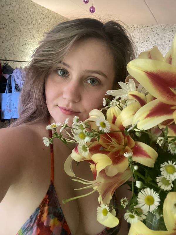 Flowers, a mirror selfie, and a tabby cat at home
