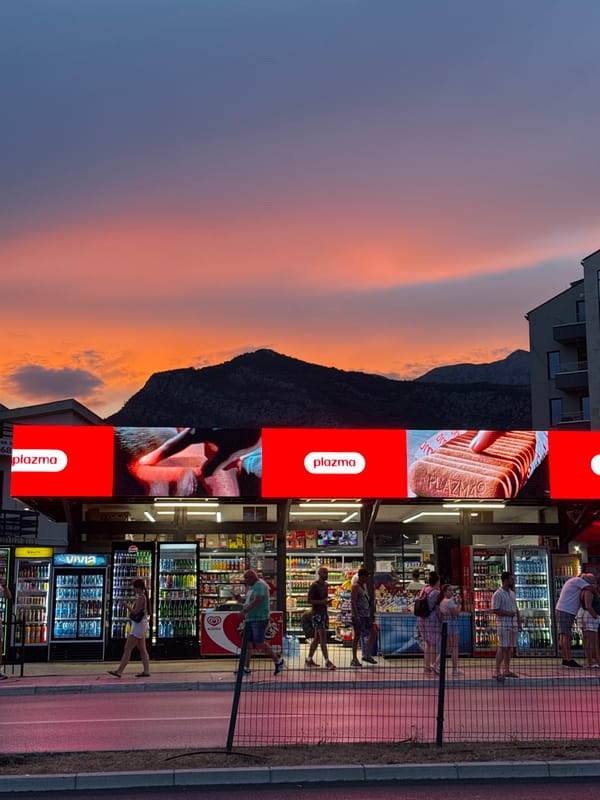 Dusk stroll past palms, storefronts, and a curved glass tower