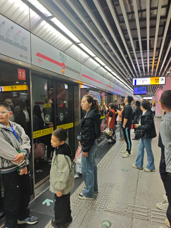 Late-night commuters wait at Lianglukou subway station in Yuzhong