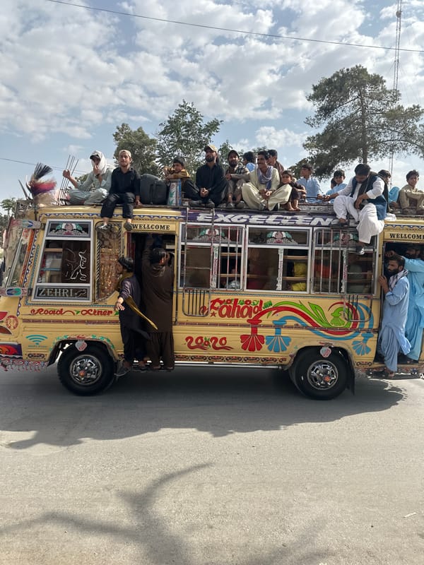 Ornately painted overloaded bus rolling down a rural road