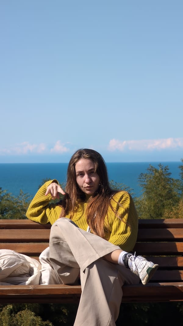 Woman rests on bench in Batumi park garden