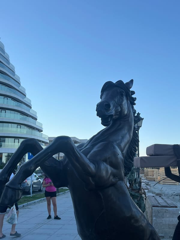 Bronze statues and modern architecture along Năvodari's waterfront promenade