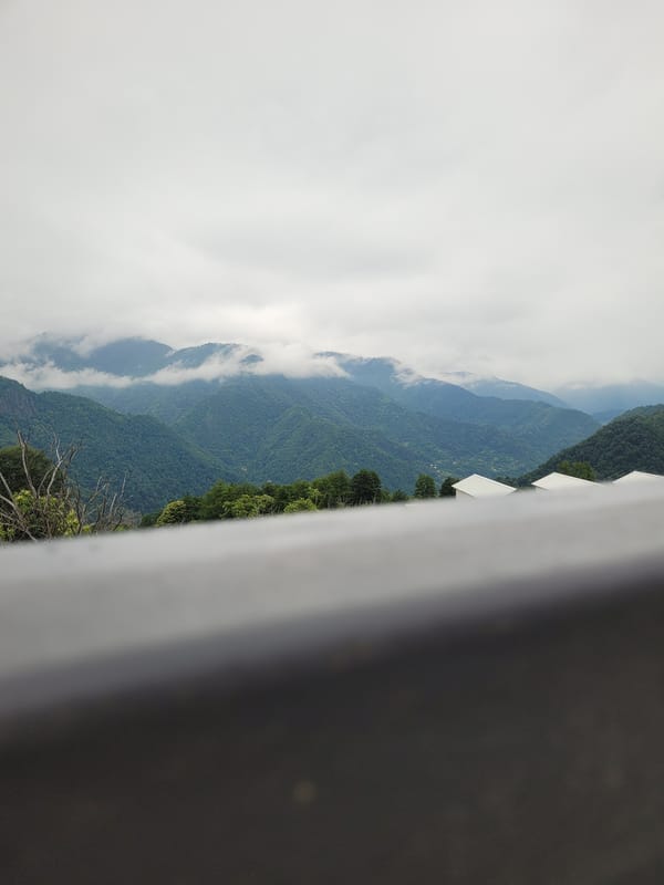 Construction and cloud-covered hills in rural Milisi, Georgia