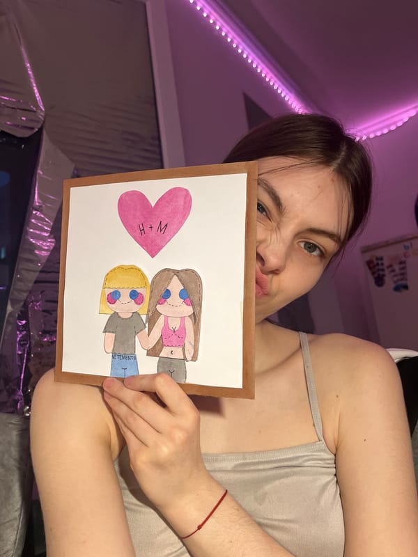 Woman displays handmade artwork featuring two figures in Saint Petersburg