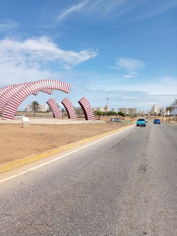 Porlamar cityscape documented from roadway with art installation visible