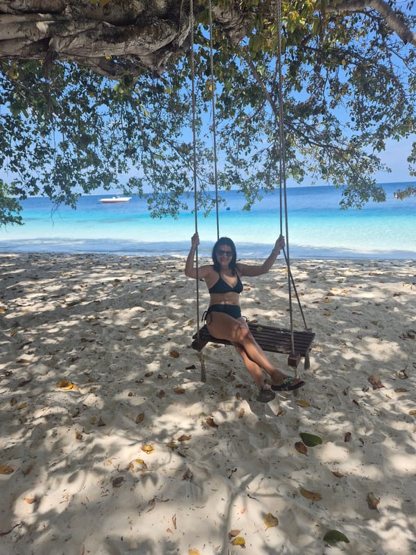 Woman enjoys rope swing at Guraidhoo beach, Maldives