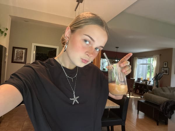 Person enjoys beverage in Whistler wearing starfish brooch