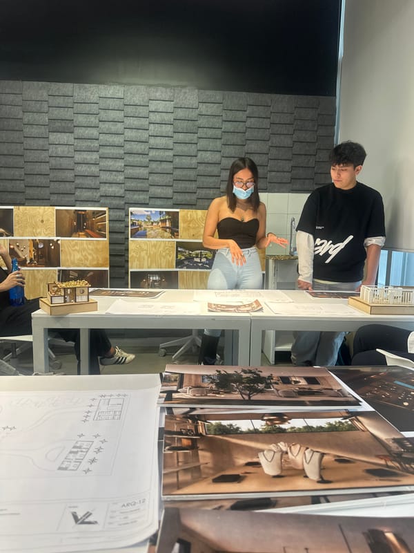 Two people review architectural plans in Mexico City workspace