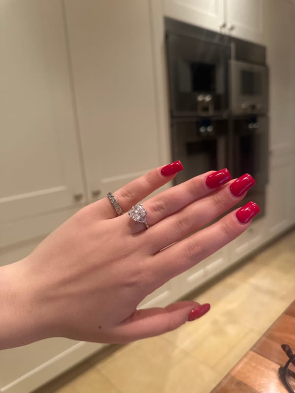 Woman shows off red nails, rings in Swiss kitchen