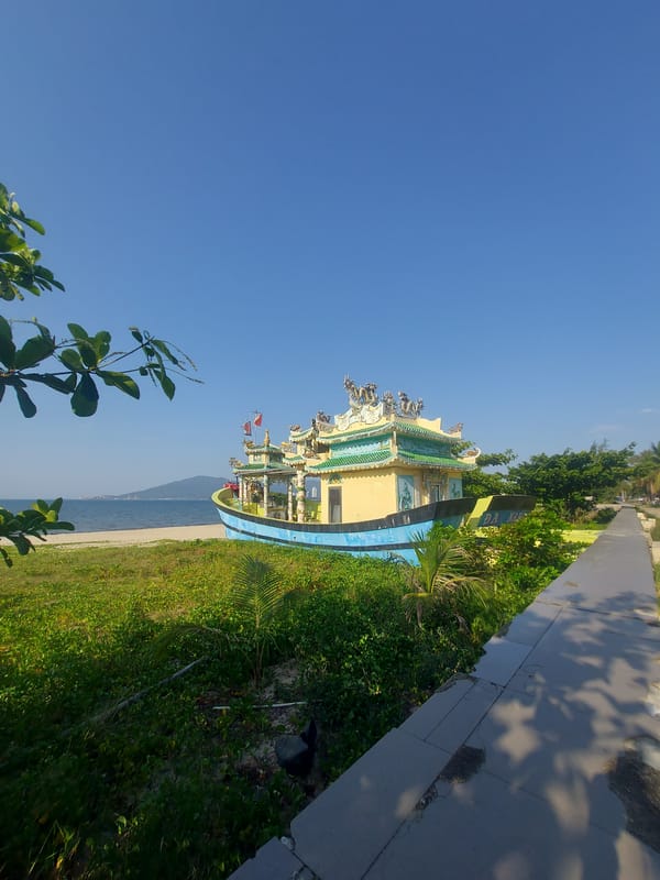 Ornate blue and yellow boat structure on the Đà Nẵng shore