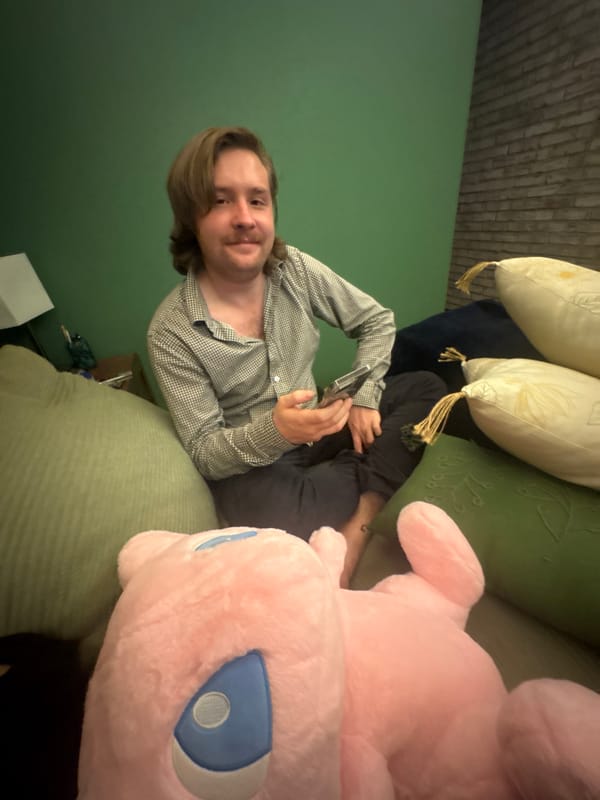 Person relaxes on sofa with pink plush toy in Mexico