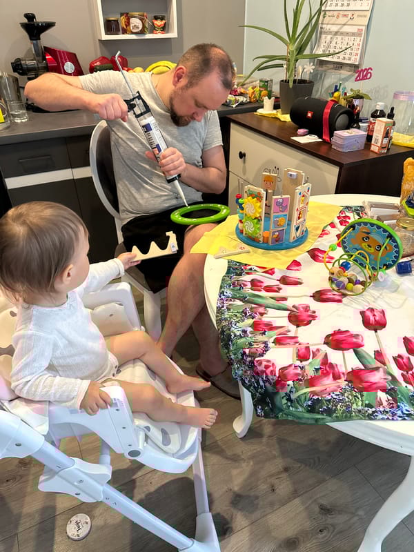 Man repairs wooden toy with caulking gun in Wisła home