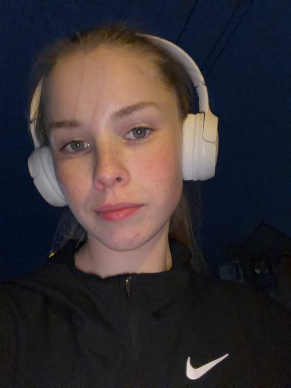 Woman in headphones walks Berezniki streets at night