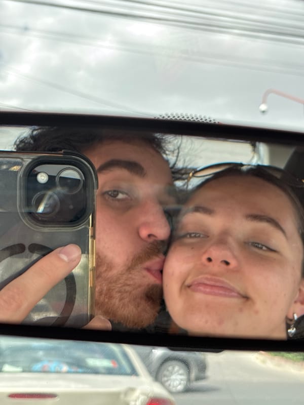 Couple takes selfie captured in car mirror reflection