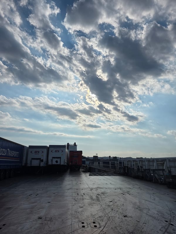 Cargo ferry operations: trucks, crew, and cloudy skies