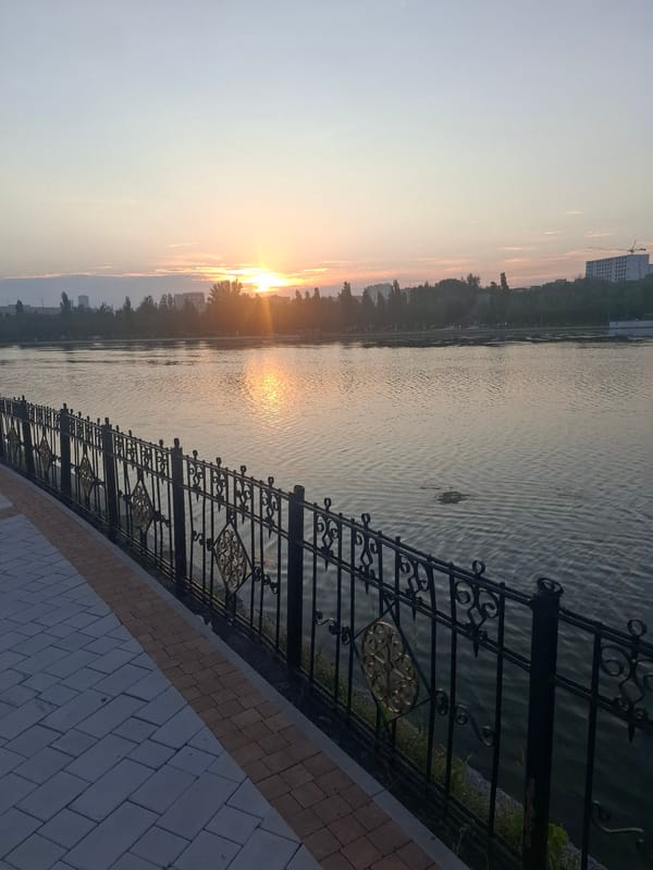 Golden light and calm water along Astana's lakeside promenade