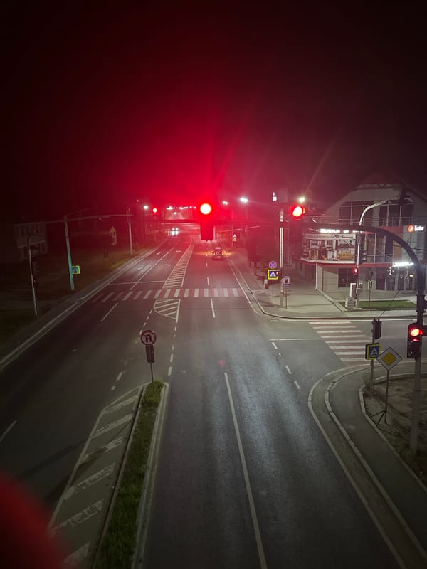 Strășeni's main street at night, storefronts to overpass