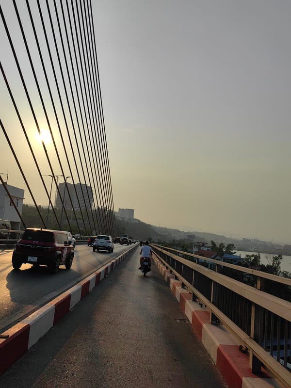 Red VinFast car travels Bai Chay Bridge Vietnam