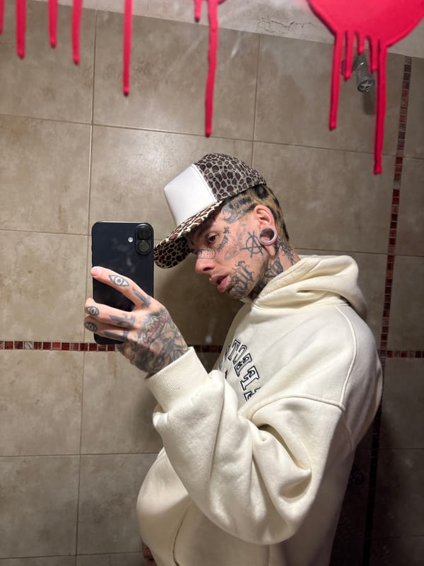 Tattooed individual takes bathroom selfie in Buenos Aires
