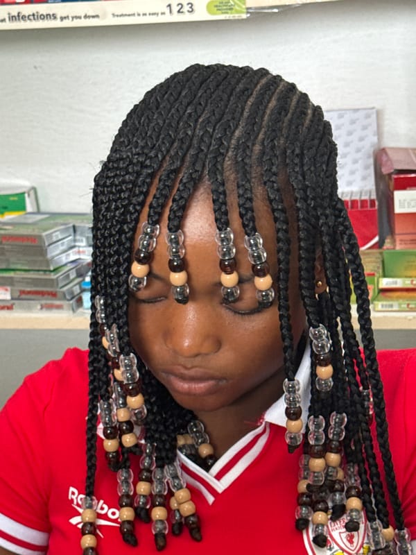 Young woman with beaded braids photographed in Ado, Nigeria