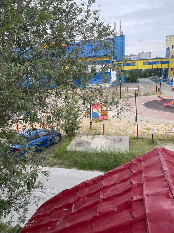 Playground area next to colorful building in Pangody, Russia