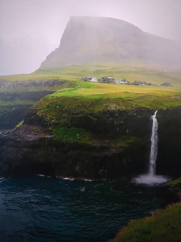 Coastal waterfall observed near settlement during sunset hours