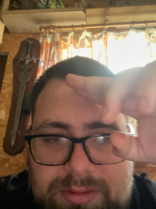Person with glasses observed near wall-mounted decorative sword