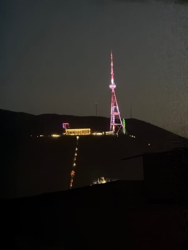 Tbilisi TV Tower displays pink and white lighting at night