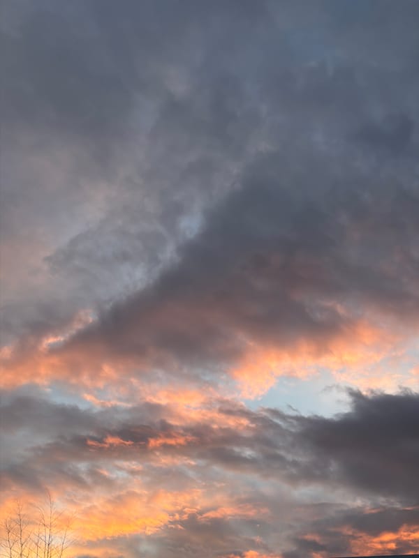 Aircraft flies through dramatic sunset skies over New Westminster