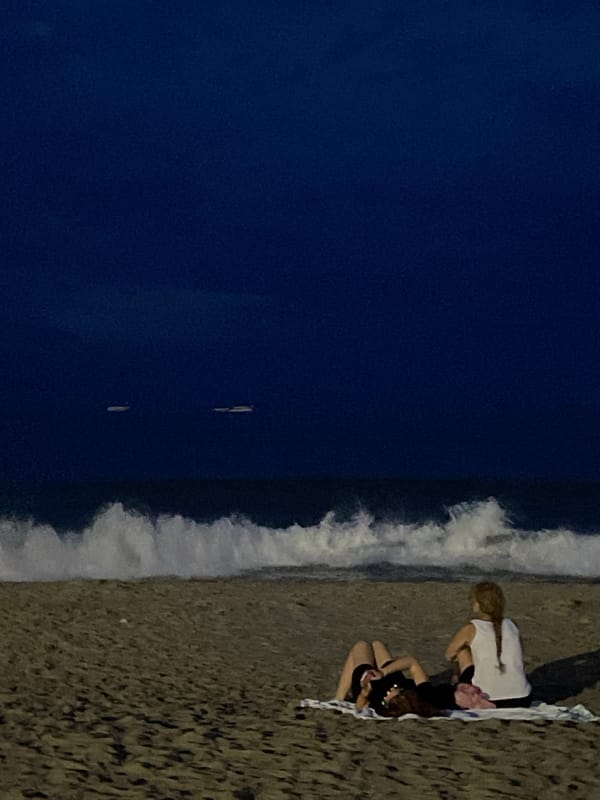Đà Nẵng beach at dusk, city lights on the horizon