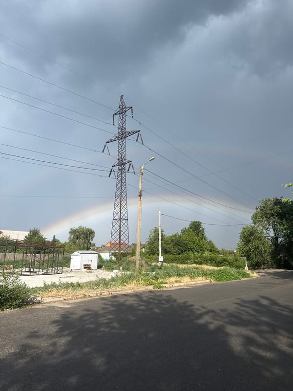 Stormy skies, a rainbow, and street signage from one location