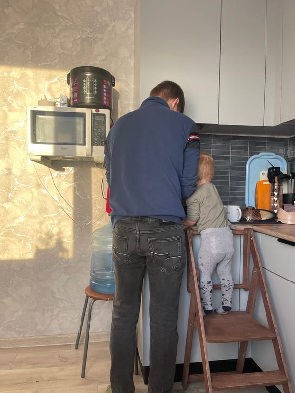 Father and child rest together on kitchen counter in Izhevsk