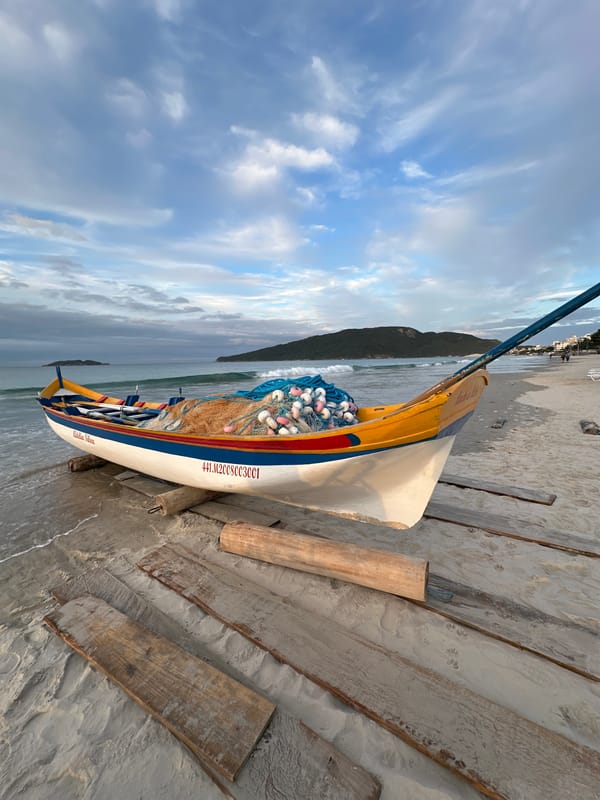 Beach life captured: fishing boat and family stroll in Florianópolis